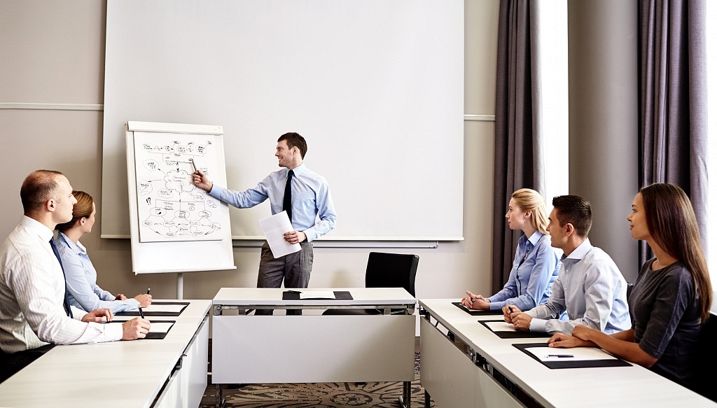 group of smiling businesspeople meeting in office